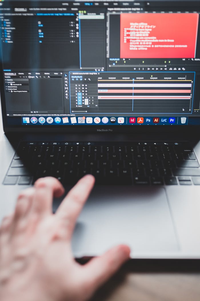 Crop unrecognizable male programmer typing on netbook while working on project and creating music