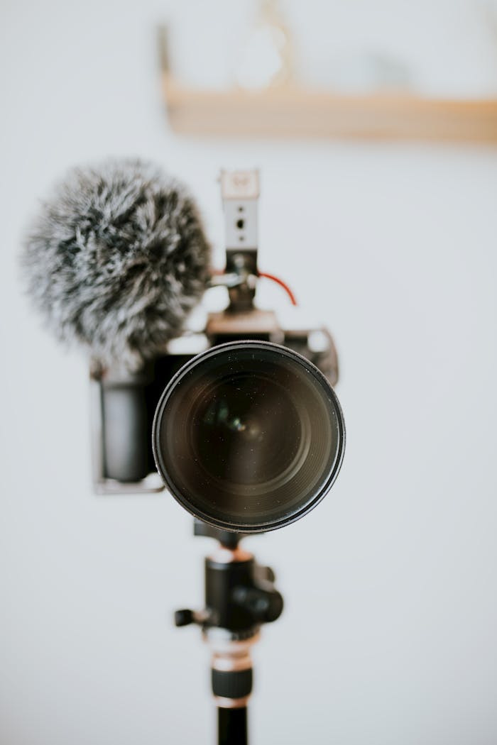 Close-up of a DSLR camera with furry microphone on tripod, perfect for vlogging or filmmaking.